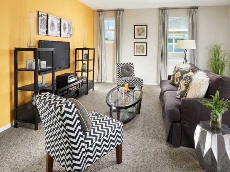 Imagem de sala de estar decorada em tom de amarelo e neutros