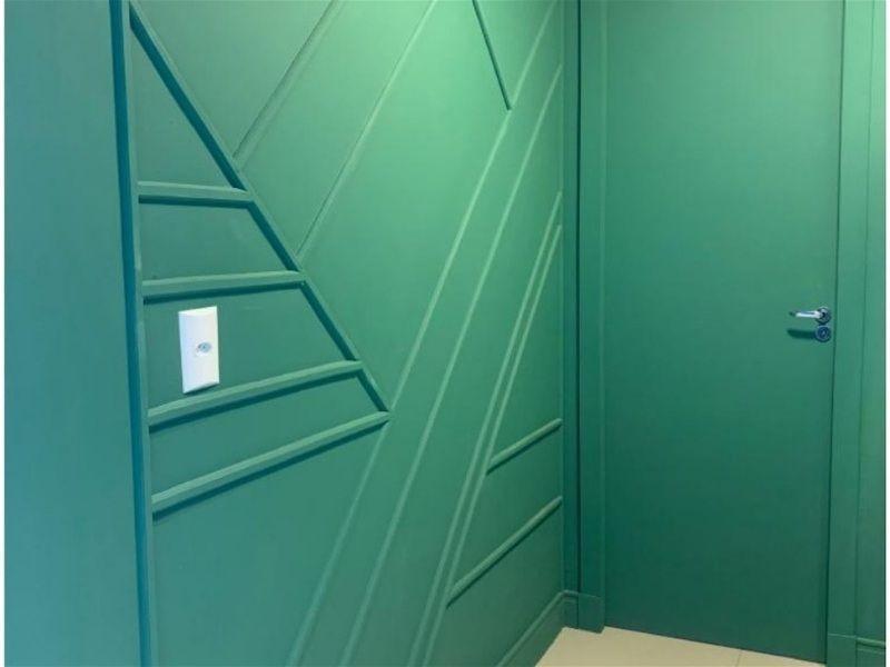 Imagem de uma parede na cor verde com painel ripado