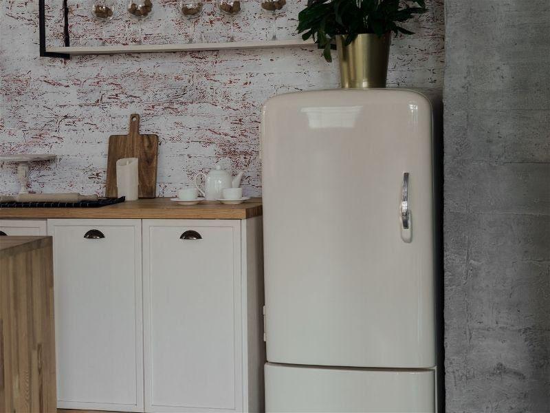 Imagem em destaque da área do armário da cozinha, contendo uma geladeira vintage ao lado