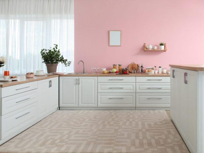 Imagem de uma cozinha decorada com elementos na cor rosa 