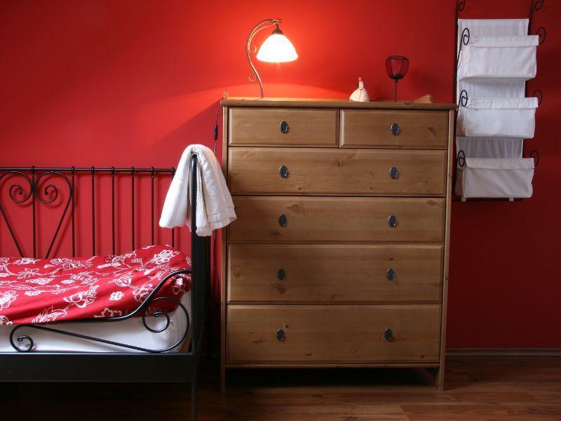 Imagem de um quarto decorado com parede vermelha