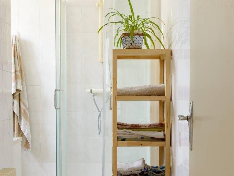 Imagem de banheiro pequeno com armários e prateleiras na decoração