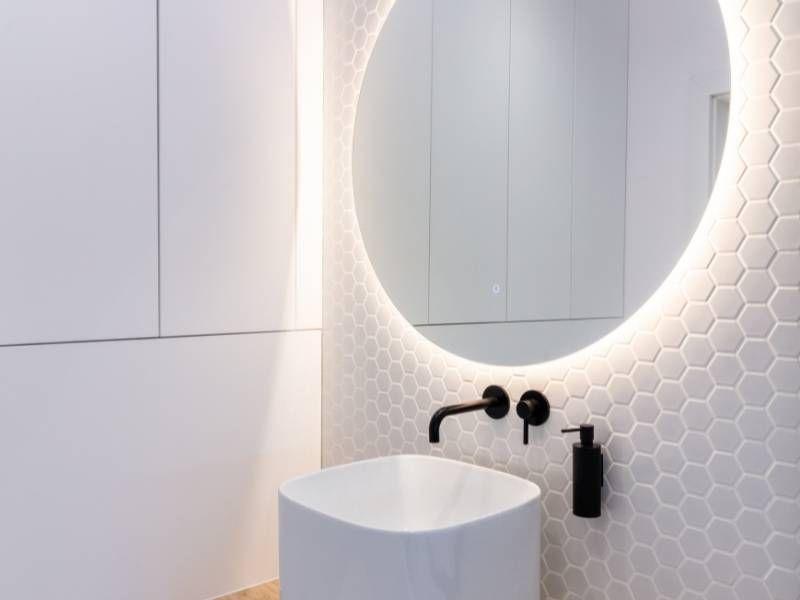 Imagem de banheiro pequeno com espelho moderno na decoração