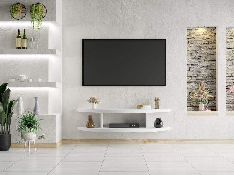 painel com TV, parede de tijolinhas e plantas