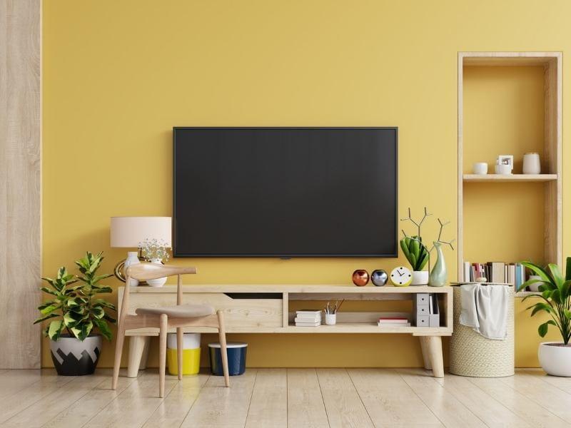 Imagem de sala de estar com parede na cor amarela