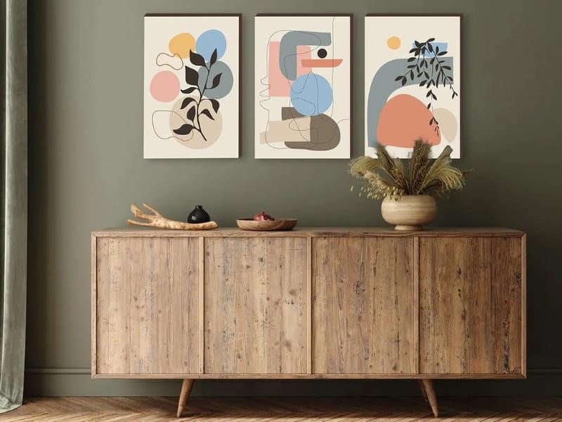parede decorada com quadros abstratos e uma mesa de madeira