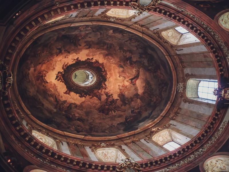 ambiente oval com o teto pintado com características do barroco
