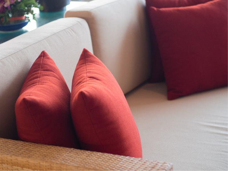 almofadas vermelhas decorando um sofá cinza