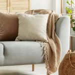 Sala com sofá e almofadas em cores neutras