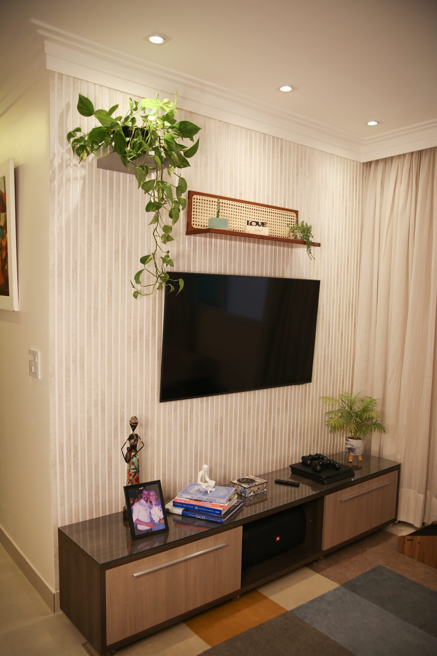 Sala de estar com painel ripado e iluminação embutida atrás da tv